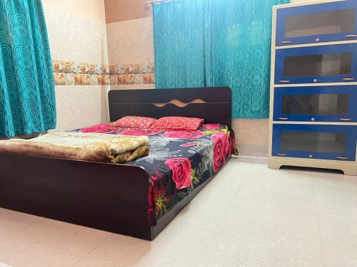 a bedroom with a bed with a black headboard and a television at Peaceful Spacious Private 1BHK Near Airport close to VIP or Jessore Rd in Nager Bazaar
