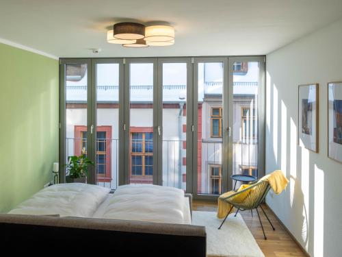 a bedroom with a bed and a large window at Altstadt Apartment for 2 in Erfurt