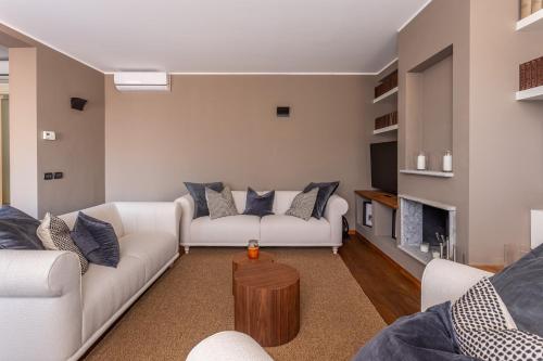 een woonkamer met 2 witte banken en een open haard bij Suite Alzaia by iCasamia in Milaan