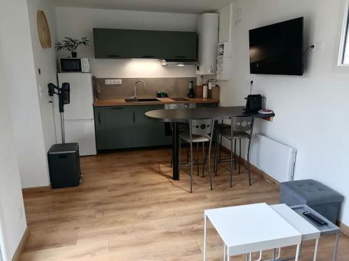 a kitchen with a table and chairs in a room at Joli chalet contemporain, calme et verdure. in Martin-Chapon