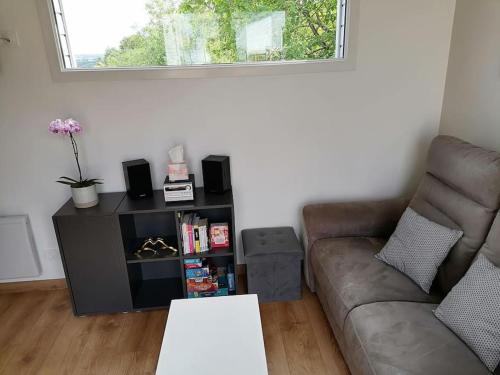 a living room with a couch and a table at Joli chalet contemporain, calme et verdure. in Martin-Chapon
