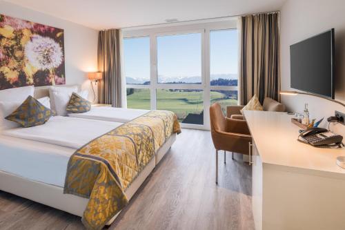 ein Hotelzimmer mit einem Bett, einem Schreibtisch und einem Fenster in der Unterkunft Hotel Swiss Star in Wetzikon