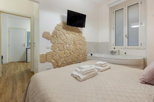 a bedroom with a bed and a bath tub and a television at Fior Di Loto Rooms in Cagliari