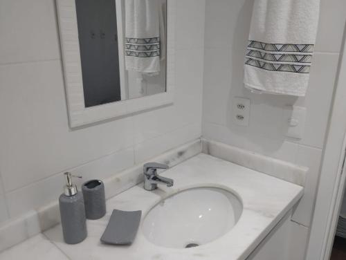 a white bathroom with a sink and a mirror at Mondial Apartments By BnbHost in Salvador