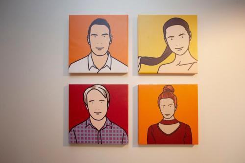 four paintings of people on a wall at higgihaus Cabot Mews #38 Sunday - Friday Central Location in Bristol