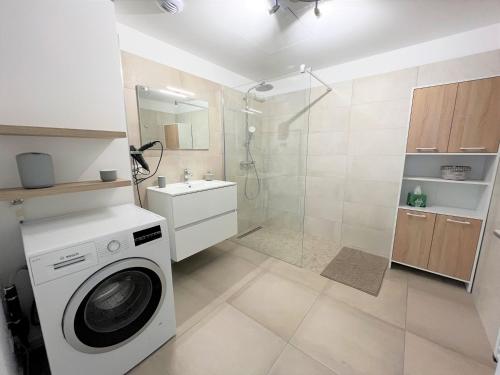 La salle de bains est pourvue d'un lave-linge et d'une douche. dans l'établissement Appartement 2 pièces Les Jardins de Livia 1 PORTICCIO, à Porticcio