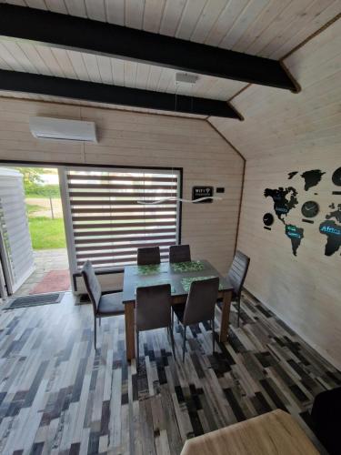 een eetkamer met een tafel en stoelen bij Domki Paradise 700m od morza !!! in Jarosławiec