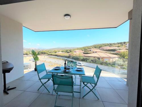 une salle à manger avec une table et des chaises et une grande fenêtre dans l'établissement Appartement 2 pièces Les Jardins de Livia 1 PORTICCIO, à Porticcio