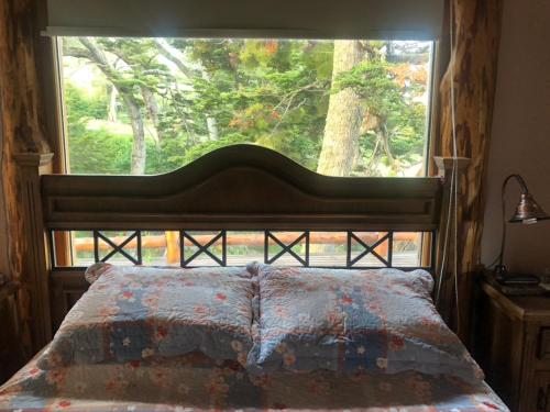 a bedroom with a bed with a large window at Morada del Leñador in Ushuaia