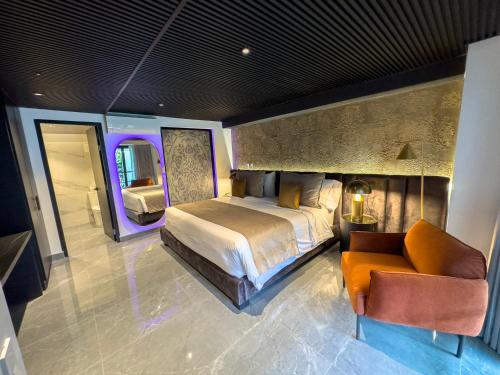 a bedroom with a bed and a couch and a chair at Haven A Design Hotel in Medellín