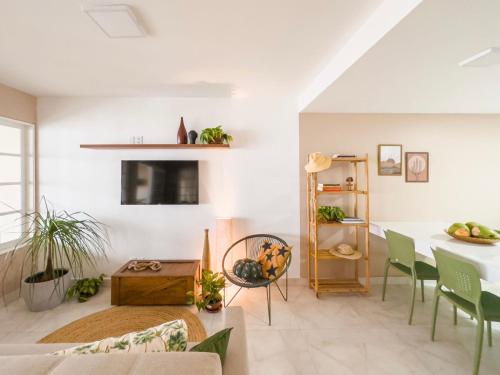 a living room with a table and green chairs at Casa Sol Ipioca in Maceió