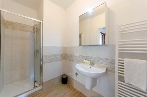 a white bathroom with a sink and a shower at Casa degli artisti 1 in Casarza Ligure