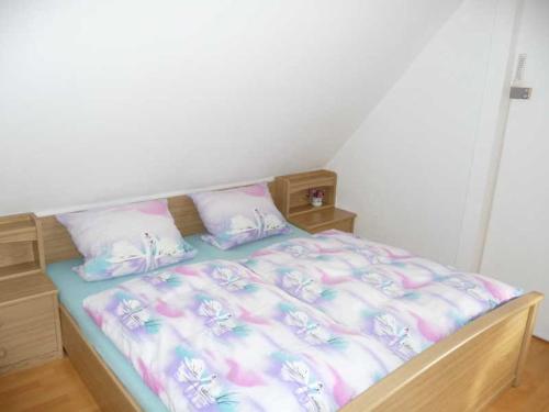 a bedroom with a bed with pink and white sheets at Ferienwohnung Kalecinski in Tautenhain