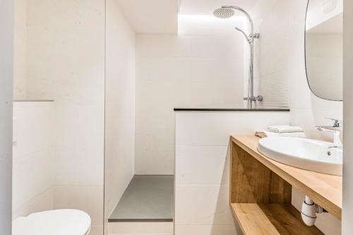a white bathroom with a sink and a mirror at Le Parc 42 Saint-Etienne in Saint-Étienne