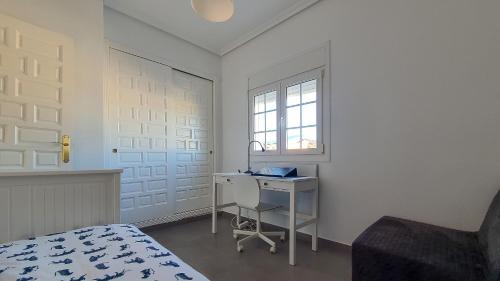 a bedroom with a desk and a bed and a window at Villa Venna, with a private pool in Baños y Mendigo