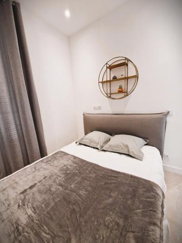 une chambre avec un lit et un miroir au mur dans l'établissement Les Capucins n°12 : APT4 pers, à Menton