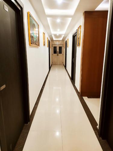 a corridor in a building with white floors at HOTEL JVS PALACE in Gorakhpur