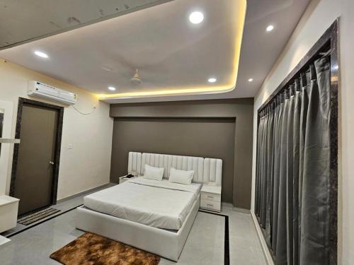 una camera con un letto bianco e una finestra di Hotel Rajhans a Kondagaon
