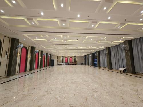 a large room with a large dance floor with red surfboards at Hotel Rajhans in Kondagaon