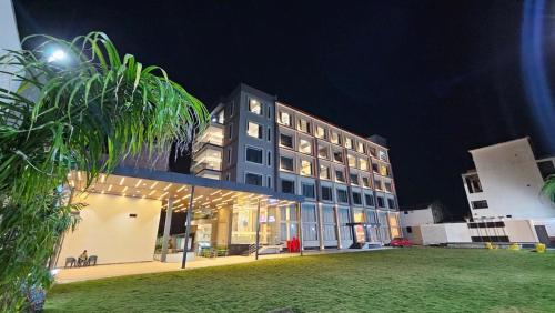 a large building at night with a green field at Hotel Rajhans in Kondagaon