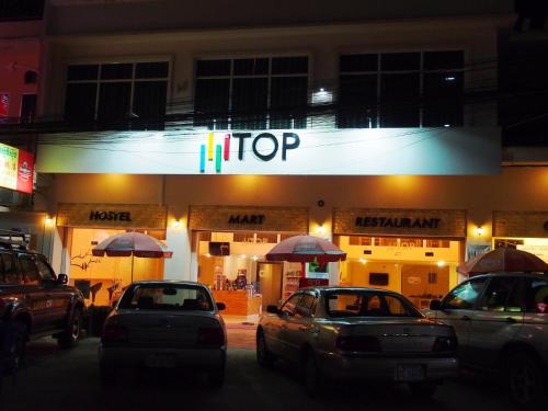 a store at night with cars parked in front of it at TOP Hostel in Phnom Penh