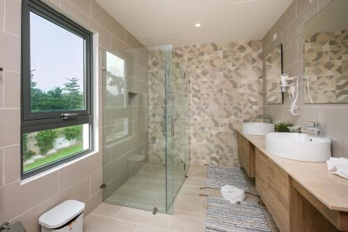 a bathroom with two sinks and a glass shower at Amar'e Aparthotel & Spa in Las Terrenas