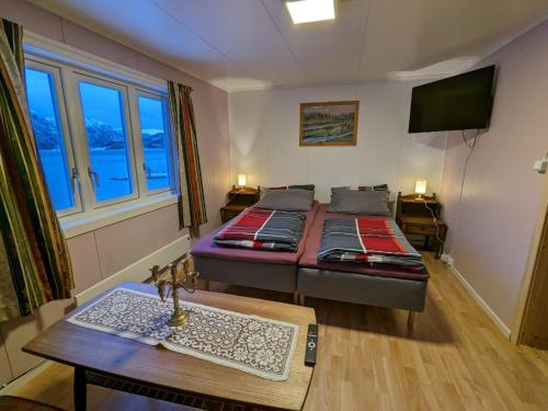 Sala de estar con 2 camas y mesa en Overnatting Rodal, en Valsøybotn