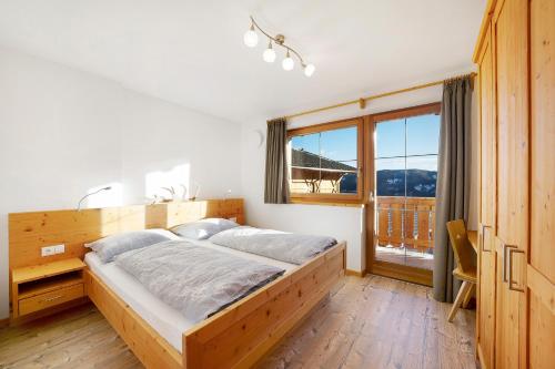 a bedroom with a large bed and a large window at Unterdurachhof Apartment Valentina in Ultimo