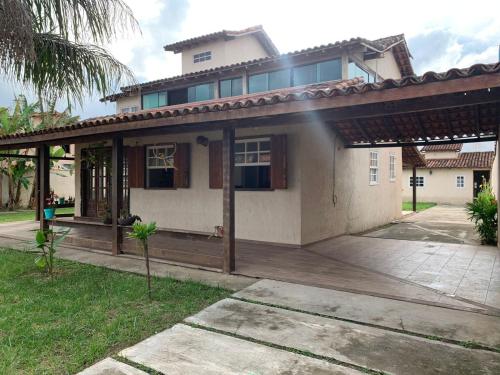 a house with a porch and a house at Recanto do Peixe Dourado kitnet in Casimiro de Abreu