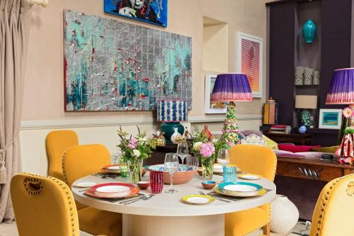 a dining room with a table and yellow chairs at Priory Barn in Binham