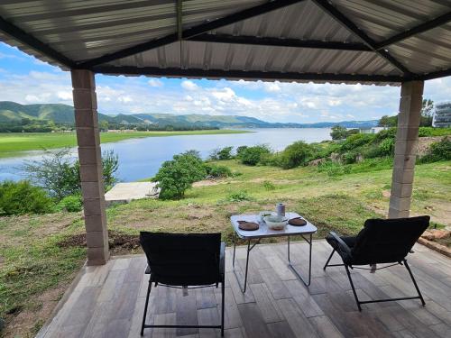 a table and chairs on a patio with a view of a lake at Balcones del Lago in Villa Parque Siquiman