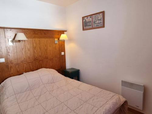 une chambre avec un lit et un tableau au mur dans l'établissement Appartement cosy à Plagne Soleil, balcon, 5 personnes, casier à skis - FR-1-181-2730, à La Plagne Tarentaise