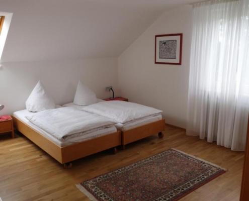 - une chambre avec un lit et un tapis au sol dans l'établissement Haus Wörle, à Nonnenhorn