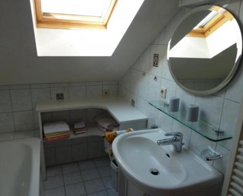 La salle de bains est pourvue d'un lavabo, d'un miroir et d'une baignoire. dans l'établissement Haus Wörle, à Nonnenhorn