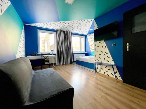 sypialnia z niebieskimi ścianami, łóżkiem i oknem w obiekcie Good Times House w mieście Katowice
