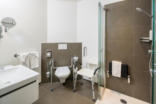 a bathroom with a toilet and a shower at Hotel Swiss Star in Wetzikon