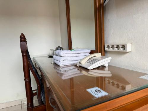 a telephone on a glass counter in front of a mirror at Hotel Priangan in Cirebon