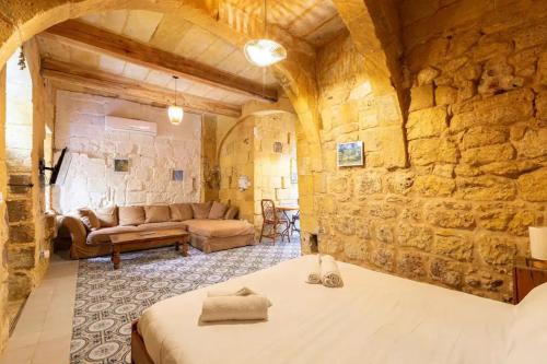 a room with a bed and a stone wall at Historic Hideaways - 900 Year Old Converted Studios in Victoria