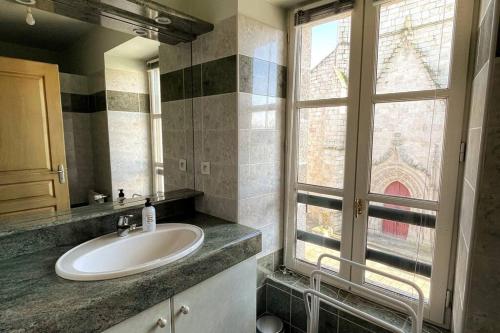 uma casa de banho com um lavatório e uma janela em Le Repère appartement centre-ville em Les Herbiers