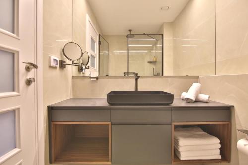 Luxury Suites by Notaly Ariel - Carmel Beach في حيفا: حمام مع حوض ومرآة