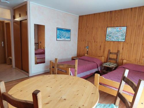 une chambre avec deux lits, une table et des chaises dans l'établissement Studio 2 Personnes, Centre Village, Wifi, Parking - FR-1-512-193, à Brides-les-Bains