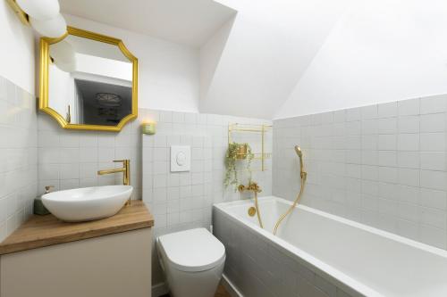 a bathroom with a sink and a toilet and a mirror at Elite Apartments Długa Prestige in Gdańsk