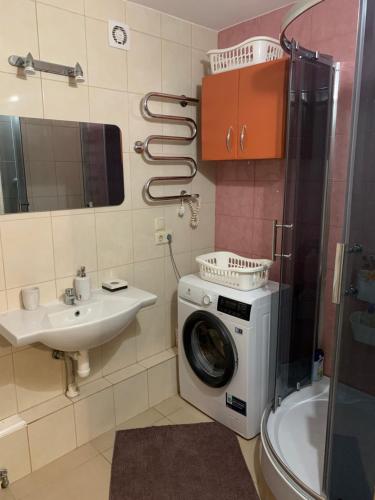 a bathroom with a washing machine and a sink at Near the airport in Mārupe