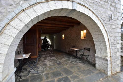 an archway in a building with tables and chairs at Nikolas Guesthouse in Koukouli