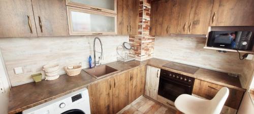eine kleine Küche mit einer Spüle und einer Mikrowelle in der Unterkunft Апартамент Холидей in Razgrad
