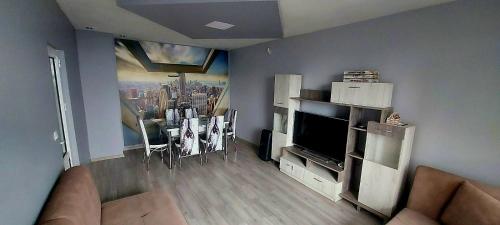 a living room with a couch and a television at Апартамент Холидей in Razgrad
