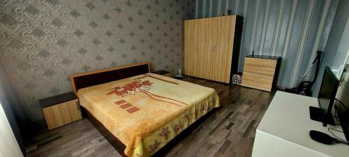 a bedroom with a bed and a dresser at Апартамент Холидей in Razgrad