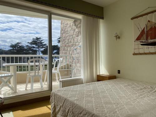 une chambre avec un lit et un balcon dans l'établissement 441 - A ERQUY, en bordure de la très belle plage de CAROUAL 2km de sables fin, à Erquy