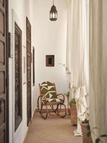 a hallway with a chair and a potted plant at IZZA Marrakech in Marrakech