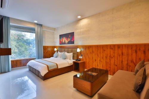 Habitación de hotel con cama y sofá en Clay Inn Hotel, Sohna Road, Sector 49, Gurugram, en Gurgaon